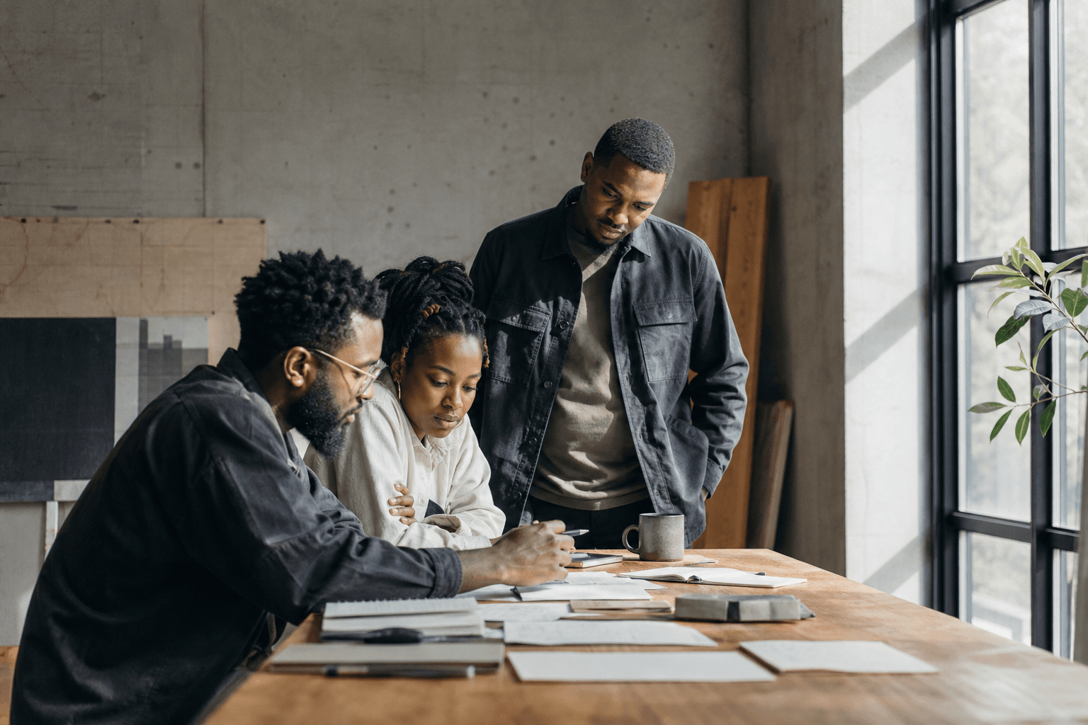 Three adults working through ideas together around a table